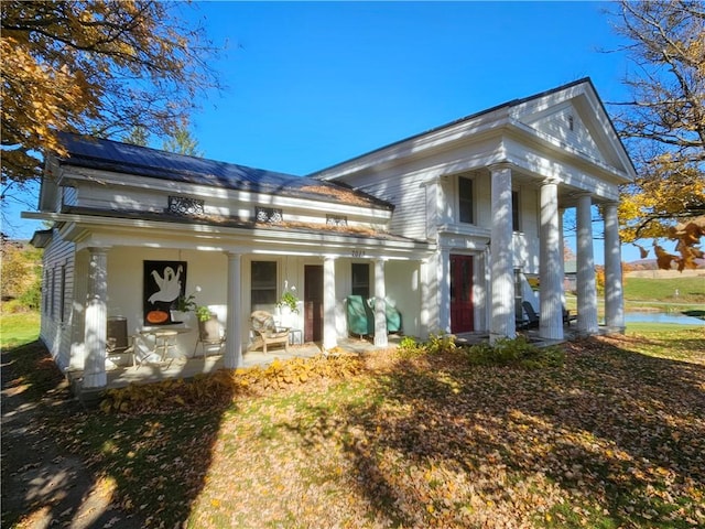 view of front of home featuring solar panels and covered porch