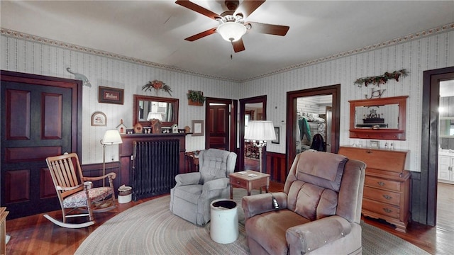 living area with hardwood / wood-style flooring, radiator, and ceiling fan