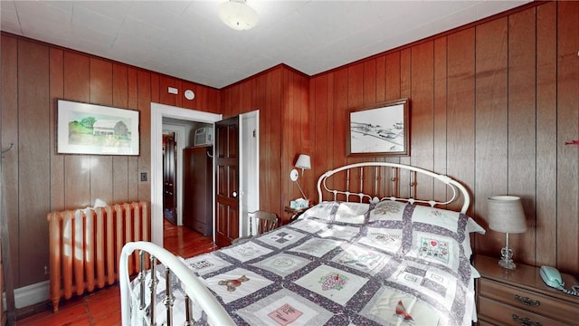 bedroom with wood walls and radiator