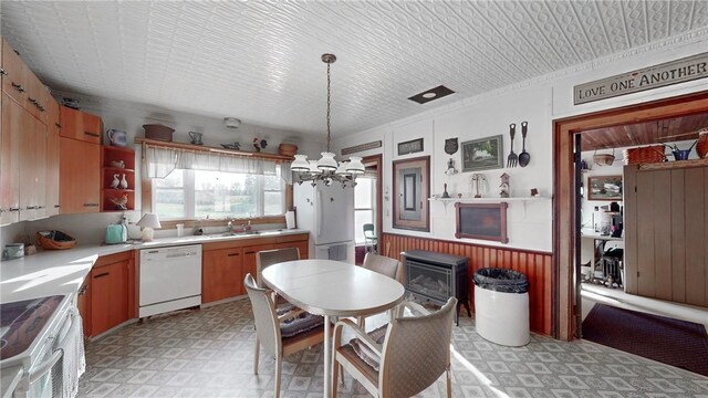 kitchen featuring white dishwasher, sink, ornamental molding, decorative light fixtures, and range