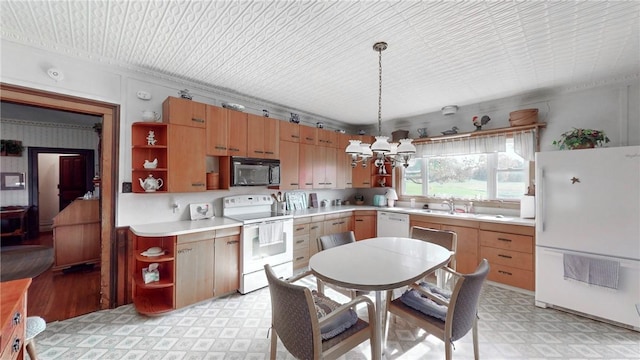 kitchen with a chandelier, white appliances, decorative light fixtures, and sink