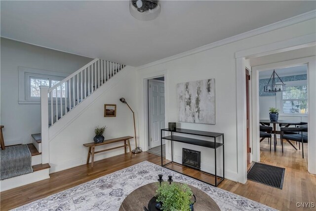 living room featuring hardwood / wood-style floors, a chandelier, and ornamental molding