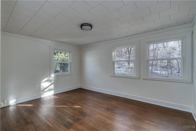 empty room featuring dark hardwood / wood-style floors and ornamental molding