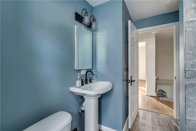 bathroom with hardwood / wood-style flooring and toilet