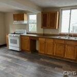 kitchen with white range oven, range hood, and sink