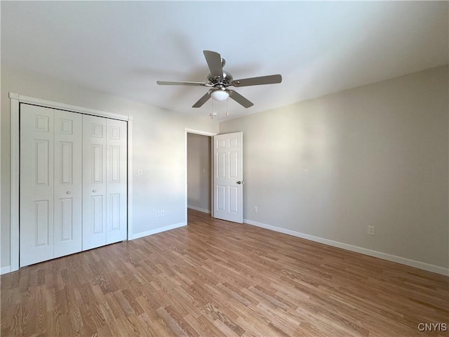 unfurnished bedroom with ceiling fan, light wood-type flooring, and a closet