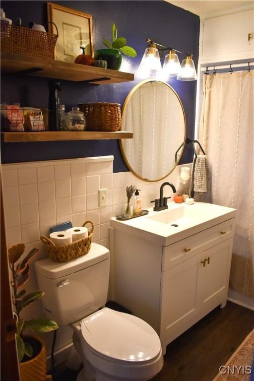 bathroom with decorative backsplash, vanity, wood-type flooring, and toilet