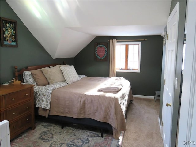 bedroom featuring light colored carpet and lofted ceiling