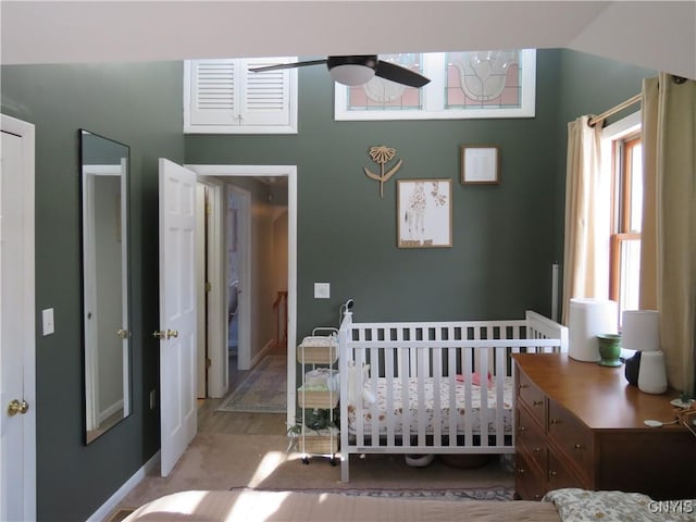 bedroom with ceiling fan and a nursery area