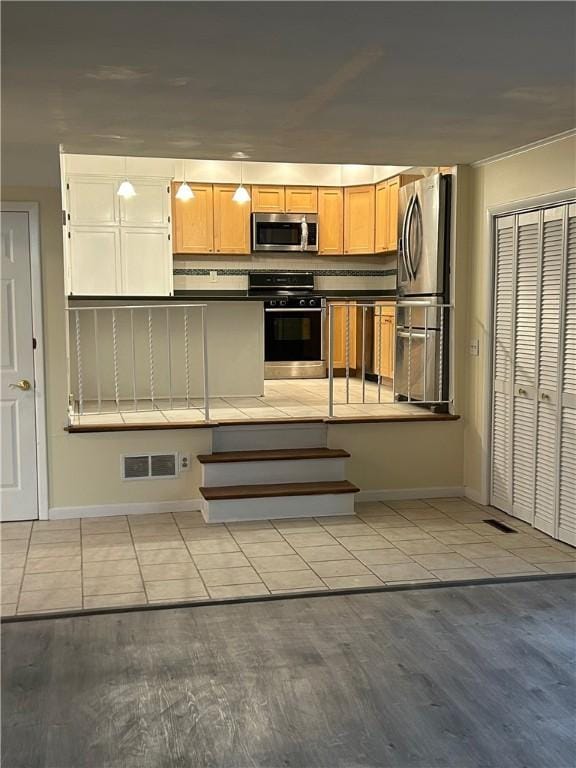 kitchen with decorative backsplash, light hardwood / wood-style flooring, and appliances with stainless steel finishes