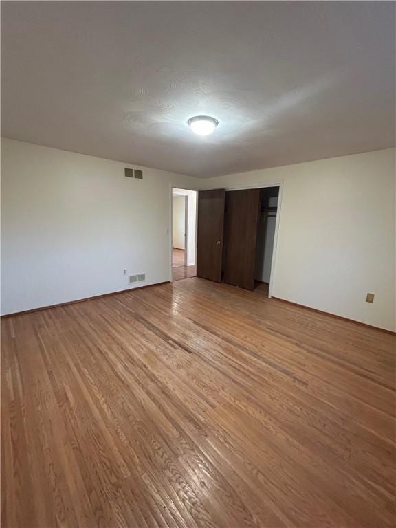 unfurnished bedroom with light hardwood / wood-style flooring and a closet