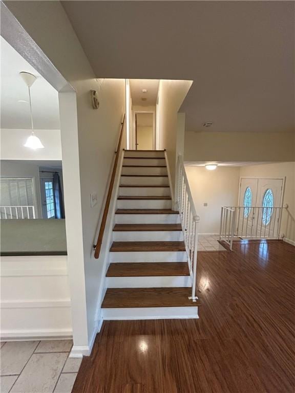 staircase featuring french doors and hardwood / wood-style floors