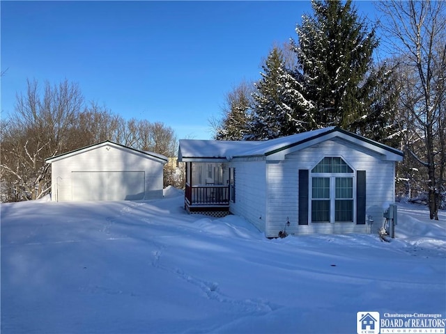 view of snow covered exterior featuring an outbuilding and a garage