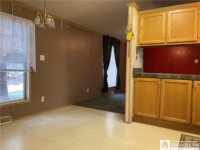 kitchen featuring a textured ceiling and a notable chandelier