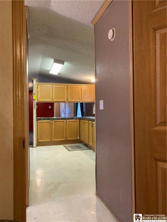 kitchen featuring a textured ceiling and lofted ceiling