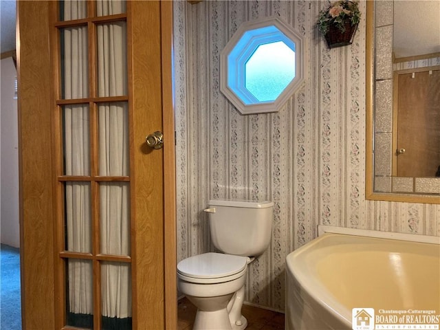 bathroom with a tub and toilet