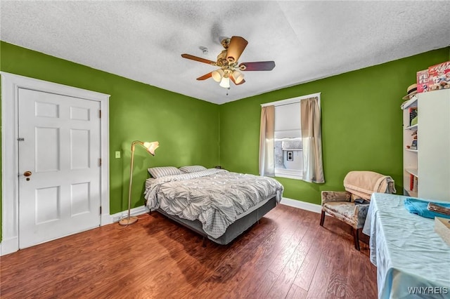 bedroom featuring a textured ceiling, ceiling fan, and dark wood-type flooring