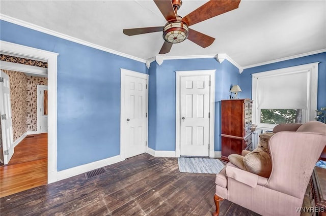 living area with dark wood-type flooring, ceiling fan, and ornamental molding