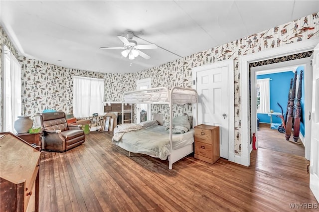 bedroom featuring multiple windows, wood-type flooring, and ceiling fan