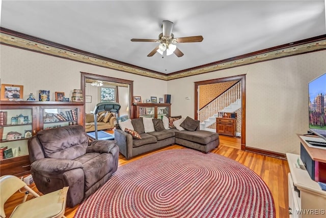 living room with ceiling fan, ornamental molding, and light hardwood / wood-style flooring