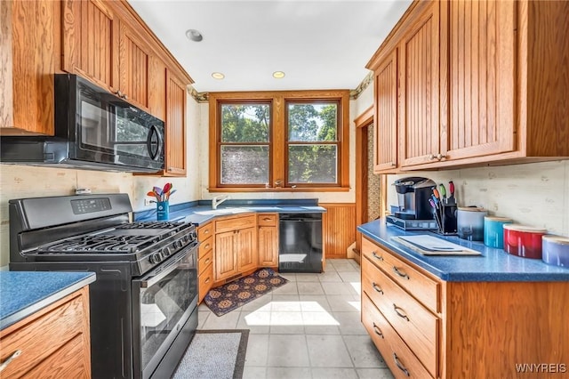 kitchen featuring black appliances, light tile patterned flooring, and sink