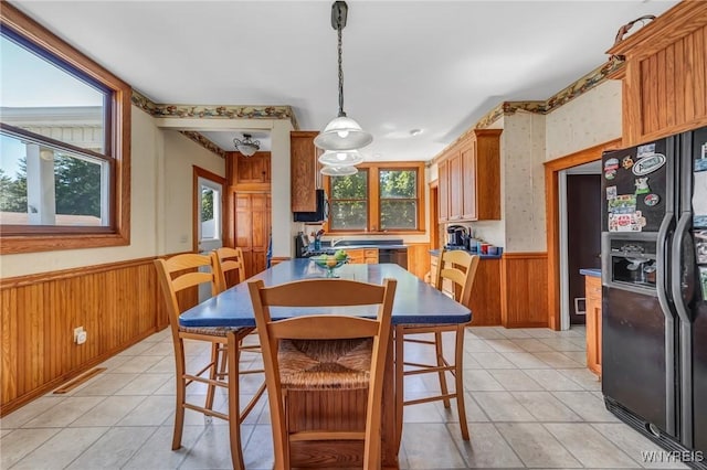 dining area with wood walls and light tile patterned floors