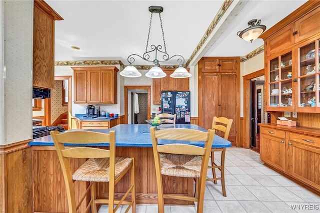 dining room featuring light tile patterned floors and wood walls