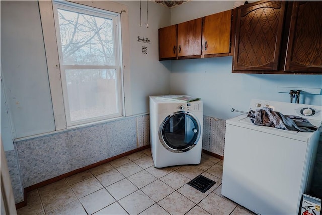 washroom featuring cabinets, independent washer and dryer, and light tile patterned floors