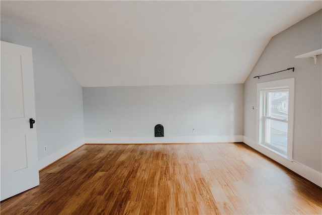 additional living space featuring wood-type flooring and vaulted ceiling