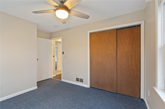 unfurnished bedroom featuring ceiling fan, a closet, and dark colored carpet