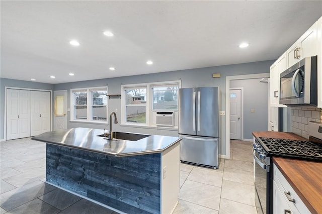 kitchen with white cabinets, sink, an island with sink, and appliances with stainless steel finishes