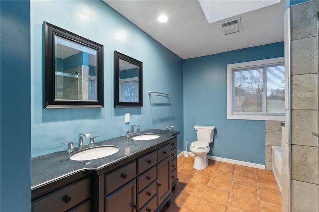 bathroom featuring toilet, a bath, vanity, and tile patterned floors