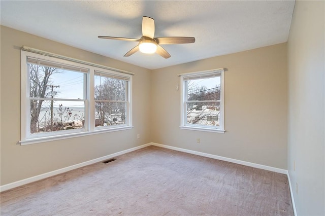 carpeted spare room with ceiling fan