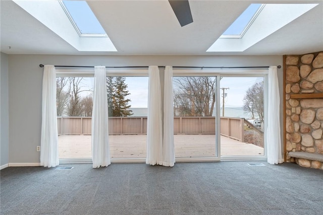 unfurnished living room featuring carpet flooring and a skylight