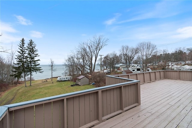 deck with a water view and a lawn