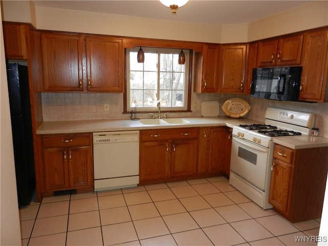 kitchen with sink, light tile patterned floors, black appliances, and tasteful backsplash