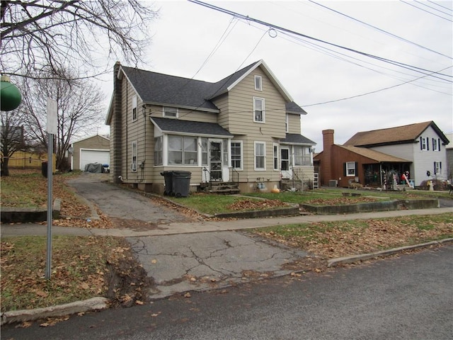 view of front of house with a garage and an outdoor structure