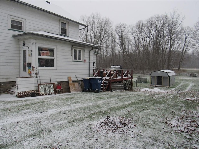 view of side of property with a lawn, a storage unit, and a deck