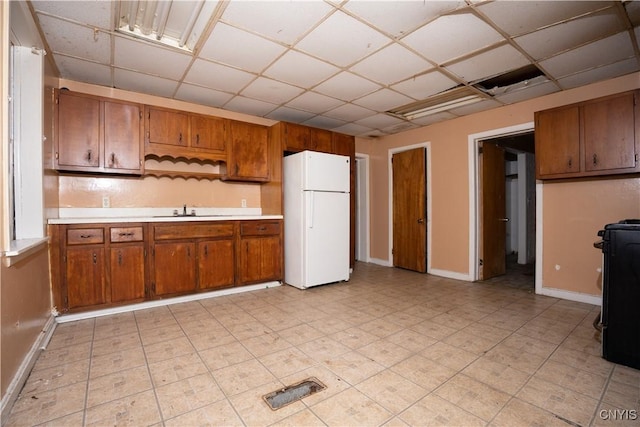 kitchen featuring sink, a drop ceiling, range, and white fridge