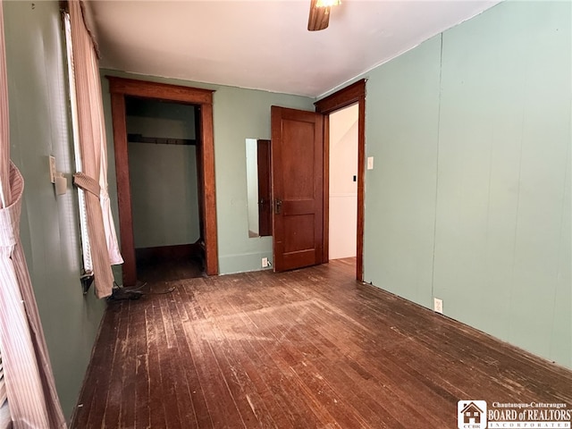 unfurnished bedroom featuring ceiling fan, dark hardwood / wood-style floors, and a closet