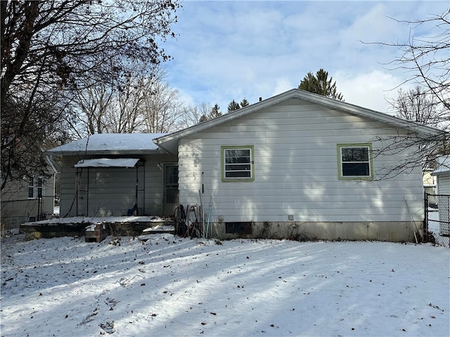 view of snow covered back of property