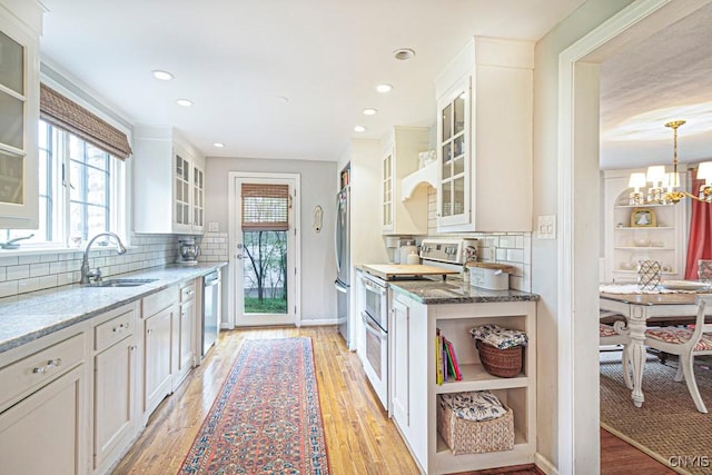 kitchen featuring stone counters, white cabinetry, sink, and appliances with stainless steel finishes