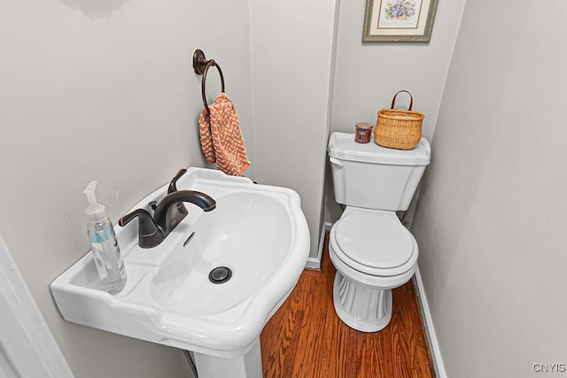 bathroom with sink, hardwood / wood-style floors, and toilet