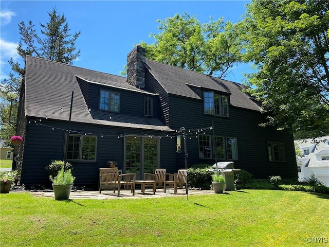 rear view of house with a yard and a patio area