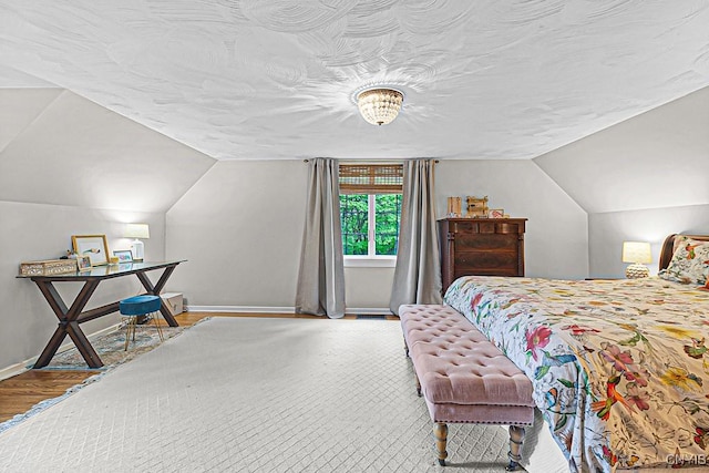 bedroom featuring hardwood / wood-style floors and lofted ceiling