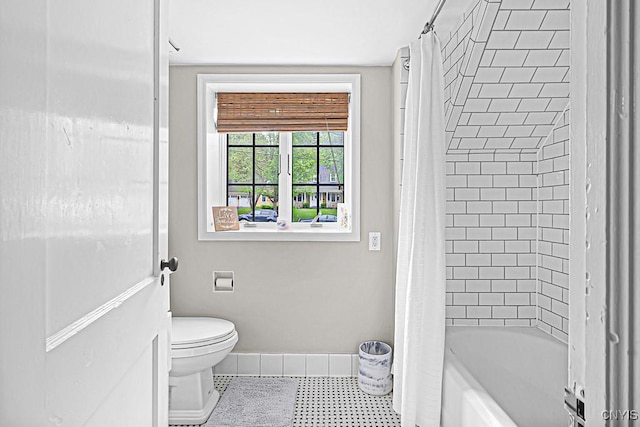 bathroom featuring shower / bath combination with curtain and toilet