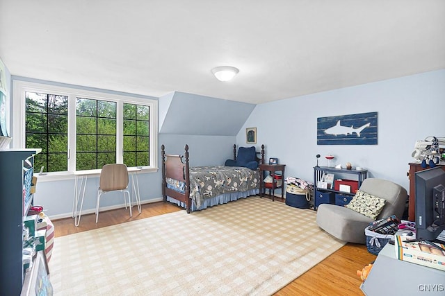 bedroom featuring wood-type flooring and vaulted ceiling