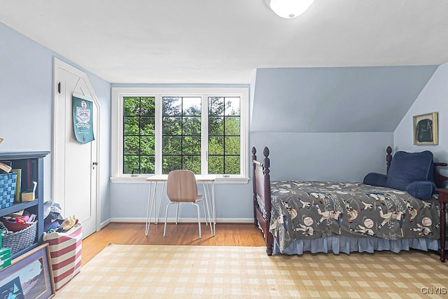 bedroom featuring light hardwood / wood-style floors and lofted ceiling