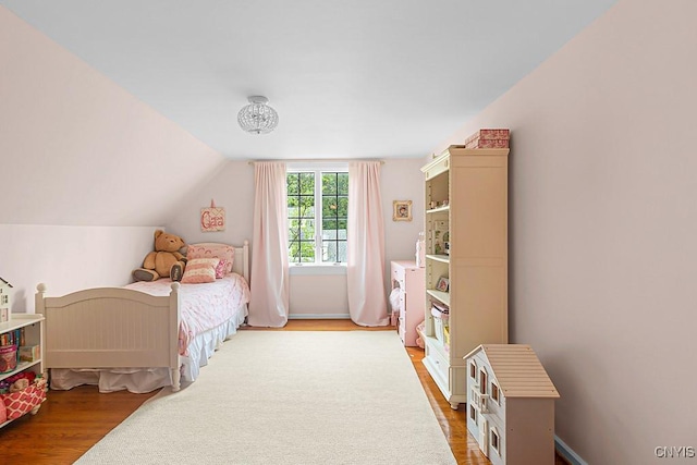 bedroom with wood-type flooring and lofted ceiling