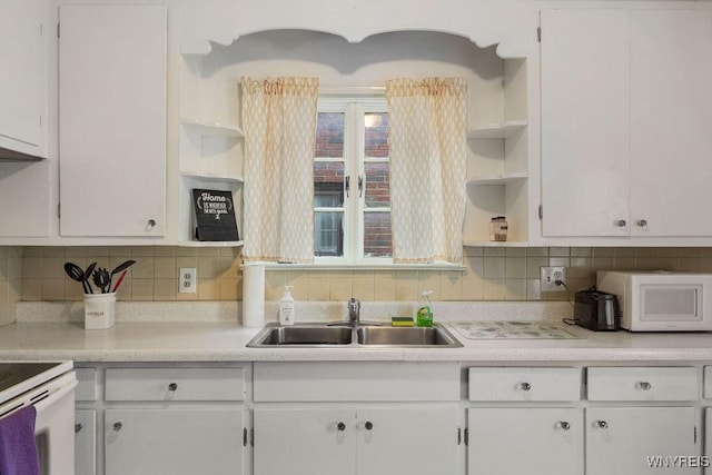 kitchen featuring white cabinets, backsplash, a healthy amount of sunlight, and sink